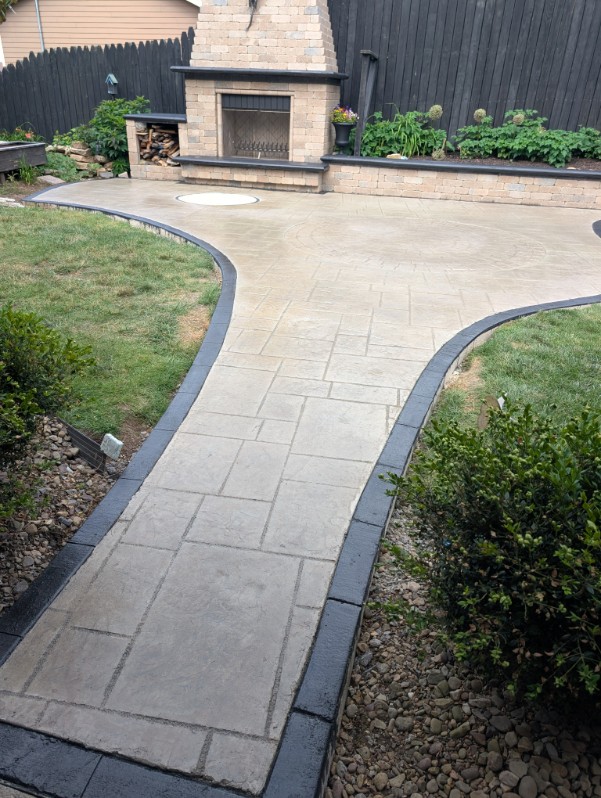 Stamped concrete walkway with charcoal border leading to an outdoor fireplace in the North Hills, PA